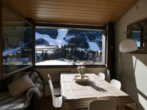 a dining room with a table and a large window at Sol Tarter - Vacances Pirinenca in El Tarter