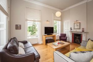 a living room with a couch and a tv at Stunning Spacious Central Apartment near Parade Gardens in Bath