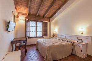 a bedroom with a bed and a desk and a television at Antico Casale in Sarzana +72 photos