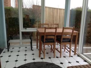 a table and chairs in a room with windows at Garden Apartment in Newton Abbot