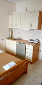 a small kitchen with white cabinets and a sink at Gorgones, sea-front, great view in Kardamili