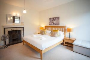1 dormitorio con 1 cama grande y chimenea en Stunning Spacious Central Apartment near Parade Gardens en Bath