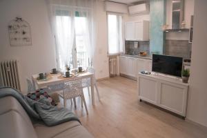 een woonkamer met een bank en een tafel en een keuken bij Saffi 15 Apartments in Bologna