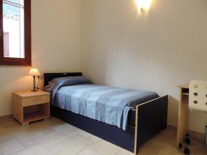 um pequeno quarto com uma cama e uma mesa em la casetta rosa em Tertenìa