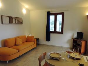 un soggiorno con divano e tavolo di la casetta rosa a Tertenìa