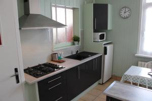 uma cozinha com um lavatório e um fogão forno superior em Le Kooka em Arras