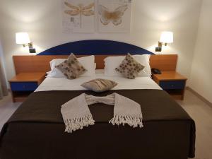 a bedroom with a large bed with two pillows on it at Roero Park Hotel in Sommariva Perno