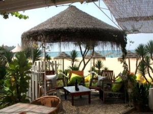 a patio with an umbrella and chairs and a table at Vila Monte Luz 3 in Ferragudo