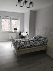 a bedroom with a bed and a table and a window at Apartament Centrum Więckowskiego in Łódź
