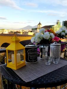 un tavolo con candele e fiori sul balcone di I Tetti Del Centro Storico a Napoli