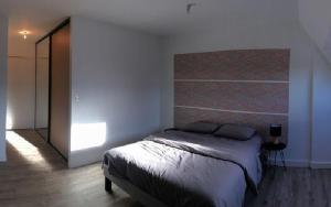 ein Schlafzimmer mit einem Bett in einem weißen Zimmer in der Unterkunft STUDIO COCON ULTRA CENTRE LE MANS in Le Mans
