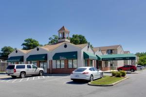 two cars parked in a parking lot in front of a building at Master Suites Hotel in Waldorf