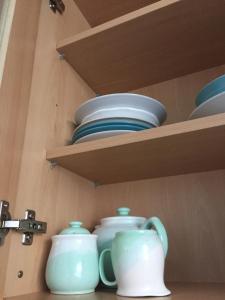 a wooden shelf with bowls and plates on it at Water side flat in Hawick