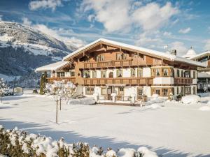 un gran edificio en la nieve frente a una montaña en Appartementhaus Sonnenschein, en Mayrhofen