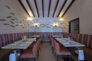 a dining room with tables and chairs and fish on the wall at Rocha Brava Village Resort in Carvoeiro