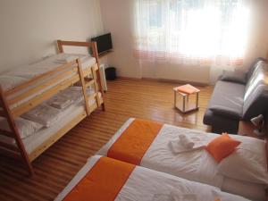 uma sala de estar com 2 beliches e um sofá em Pod Orehi em Postojna