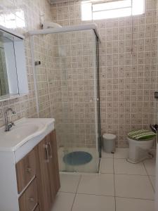 a bathroom with a shower and a sink and a toilet at Casa em Guaratuba com piscina in Guaratuba