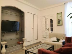 - un salon avec une télévision, une chaise et une table dans l'établissement Eco Champs Elysees, à Paris