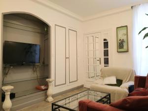 a living room with a tv and a chair and a table at Eco Champs Elysees in Paris