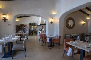 a restaurant with tables and chairs and a mirror at Rocha Brava Village Resort in Carvoeiro