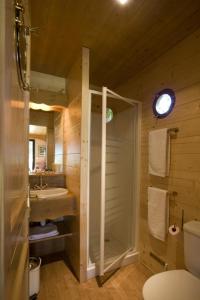 une salle de bain avec douche et lavabo dans l'établissement Gîtes Grand Pré ! et la Roulotte de Roquecor, à Roquecor