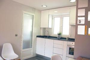 バリャドリッドにあるEl Ático de Valladolid - Centro - Terraza - Wifiの白いキャビネットとシンクのあるキッチン