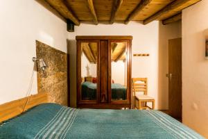 a bedroom with a bed and a mirror at Antigua Panadería de Valdelarco, chimenea con horno 2 Hab 4 pers mas 2 max in Valdelarco