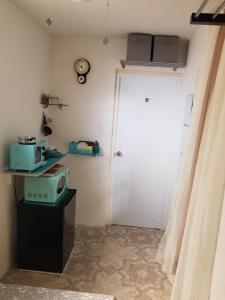 a room with a door and a microwave on a table at Tropical Delightful Guest Studio in Canovanas