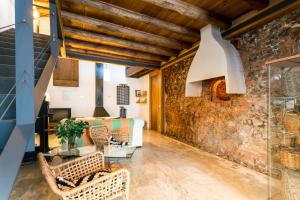 an old brick wall in a room with chairs and a table at Antigua Panadería de Valdelarco, chimenea con horno 2 Hab 4 pers mas 2 max in Valdelarco