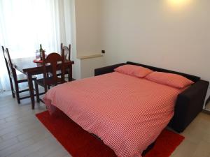 ein Schlafzimmer mit einem Bett mit einer roten und weißen gestreiften Decke in der Unterkunft Milan City Center Apartment in Mailand