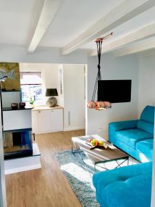 ein Wohnzimmer mit einem blauen Sofa und einem Kamin in der Unterkunft Am Dachsberg in Bad Saarow