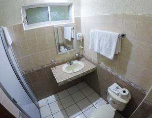 a bathroom with a toilet and a sink and a mirror at Hotel Davimar in Guamúchil