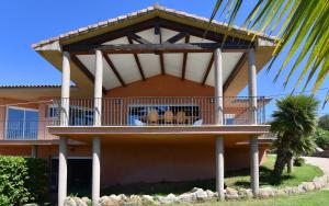 a building with a balcony with chairs on it at sci marie dominique in Olmeto