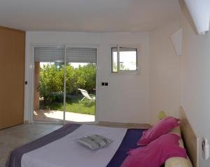 a bedroom with a bed with purple sheets and a window at sci marie dominique in Olmeto +24 photos