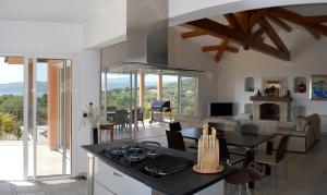 a kitchen and living room with a table and a stove at sci marie dominique in Olmeto