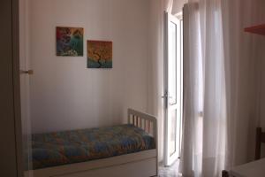 una camera con un letto accanto a una finestra di Le Case dei Pescatori - Camere Corallina a Ponza