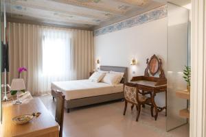 a bedroom with a bed and a desk and a table at Portica10 Assisi in Assisi