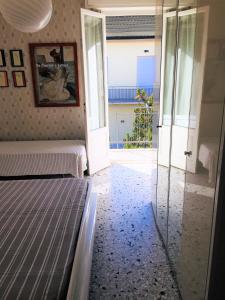 Appartamento Acquamarina في مارينا دي سيسينا: غرفة نوم بسرير وباب زجاجي