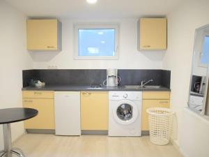 a kitchen with a washing machine and a sink at LMS Apartments in Weiterstadt