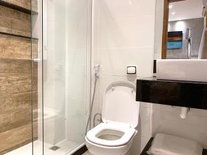um banheiro com vaso sanitário e box de vidro em The Best Apartment in Copacabana - Quarto e Sala no Rio de Janeiro mais 20 fotografias