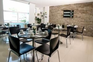 a restaurant with tables and chairs and a brick wall at Hotel San Gabriel in Barrancabermeja
