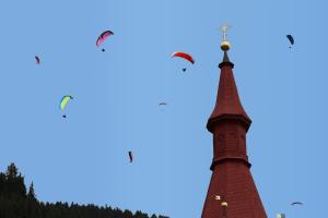 zwei Vögel, die über einem Turm fliegen in der Unterkunft Nigglhofer in Obertilliach