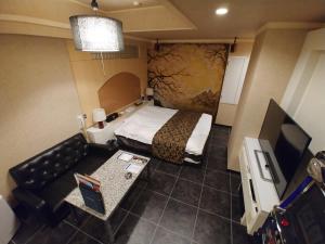 a small hotel room with a bed and a couch at Hotel Allure (Adult Only) in Nagoya