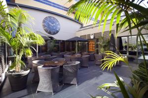 um restaurante com plantas e mesas e um relógio na parede em Hotel Solverde Spa and Wellness Center em Vila Nova de Gaia