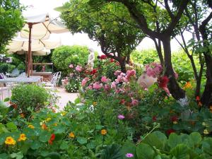 a garden with colorful flowers and an umbrella at Le Hameau in Saint Paul de Vence