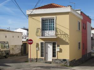 a yellow building with a balcony on a street at Zambeachouse - Beach & Country in Lourinhã
