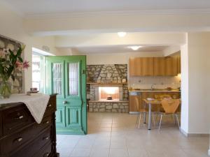 uma cozinha com uma porta verde e uma mesa em C. Katopodis Mansion em Meganisi