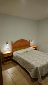um quarto com uma cama e duas mesas de cabeceira em Can Gusó em Castelló d'Empúries