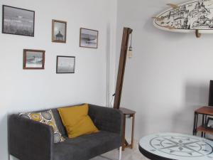 a living room with a couch and a surfboard on the wall at Zambeachouse - Beach & Country in Lourinhã