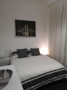 Dormitorio blanco con cama blanca y mesa en Angolo di isa, en Busto Arsizio